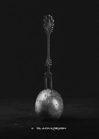 Svartvitt foto på en antik gaffel intryckt i ett plommon.