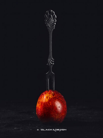 foto på en gaffel intryckt i ett färggrant plommon.