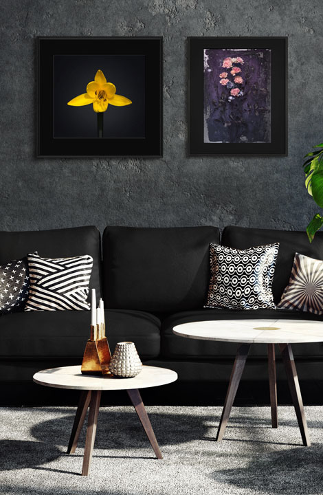 Digital fotokonst med två blommotiv på en vägg i ett rum med mörk inredning.